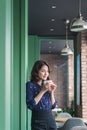 Portrait of happy young business woman with mug in hands drinking coffee in the morning at restaurant Royalty Free Stock Photo