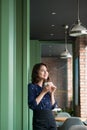 Portrait of happy young business woman with mug in hands drinking coffee in the morning at restaurant Royalty Free Stock Photo