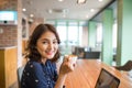 Portrait of happy young business woman with mug in hands drinking coffee in the morning at restaurant Royalty Free Stock Photo