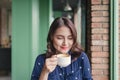 Portrait of happy young business woman with mug in hands drinking coffee in the morning at restaurant Royalty Free Stock Photo