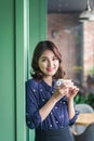 Portrait of happy young business woman with mug in hands drinking coffee in the morning at restaurant Royalty Free Stock Photo