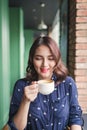 Portrait of happy young business woman with mug in hands drinking coffee in the morning at restaurant Royalty Free Stock Photo