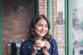 Portrait of happy young business woman with mug in hands drinking coffee in the morning at restaurant Royalty Free Stock Photo