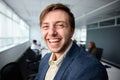 Portrait of happy young businessman in businesswear smiling next to desk in office Royalty Free Stock Photo