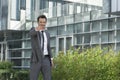 Portrait of happy young businessman pointing at you outside office building Royalty Free Stock Photo