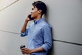 Portrait of a Happy Young Businessman Using Mobile Phone. Lifestyle of Modern People. Standing by the Wall Royalty Free Stock Photo