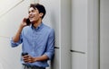 Portrait of a Happy Young Businessman Using Mobile Phone. Lifestyle of Modern People. Standing by the Wall Royalty Free Stock Photo