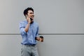 Portrait of a Happy Young Businessman Using Mobile Phone. Lifestyle of Modern People. Standing by the Wall Royalty Free Stock Photo