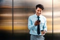 Portrait of a Happy Young Businessman Using Mobile Phone in the Urban City. Lifestyle of Modern People. Front View. Standing by Royalty Free Stock Photo