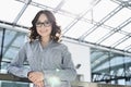 Portrait of happy young businesswoman leaning on railing in office Royalty Free Stock Photo