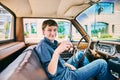 Happy young man sitting in car and holding keys Royalty Free Stock Photo