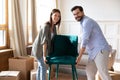 Portrait happy young couple carrying chair, placing furniture Royalty Free Stock Photo