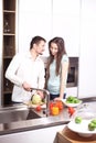 Portrait of happy young couple cooking together in the kitchen