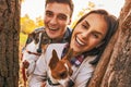 Portrait of happy young couple with dogs outdoors in autumn park Royalty Free Stock Photo