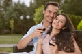 Portrait of happy young couple having red wine together in park Royalty Free Stock Photo