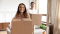 Portrait happy young couple holding boxes, moving into new house Royalty Free Stock Photo