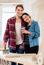 Portrait of a happy young couple holding tools for home remodeling Royalty Free Stock Photo