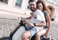 Cheerful young couple riding a scooter and having fun Royalty Free Stock Photo