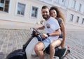 Cheerful young couple riding a scooter and having fun Royalty Free Stock Photo