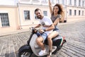 Cheerful young couple riding a scooter and having fun Royalty Free Stock Photo