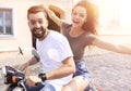 Cheerful young couple riding a scooter and having fun Royalty Free Stock Photo