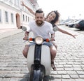 Cheerful young couple riding a scooter and having fun Royalty Free Stock Photo