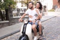 Cheerful young couple riding a scooter and having fun Royalty Free Stock Photo