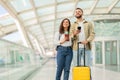 Portrait Of Happy Young Couple Standing At Airport Terminal With Luggage And Smartphone Royalty Free Stock Photo