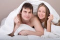 Portrait of happy young couple under blanket