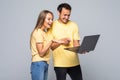 Portrait of happy young couple using laptop on gray background Royalty Free Stock Photo