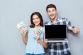 Portrait of happy young couple using laptop over gray background Royalty Free Stock Photo