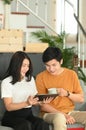 Portrait of happy young couple using tablet surfing on internet on couch. Royalty Free Stock Photo