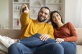 Portrait Of Happy Young Couple Watching Tv And Having Fun At Home Royalty Free Stock Photo