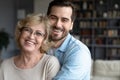 Portrait happy young european appearance man cuddling elderly retired mother. Royalty Free Stock Photo