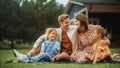 Portrait of a Happy Young Family with Kids Sitting on a Lawn in Their Front Yard on a Warm Summ Royalty Free Stock Photo