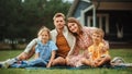 Portrait of a Happy Young Family with Kids Sitting on a Lawn in Their Front Yard on a Warm Summer Royalty Free Stock Photo