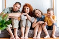 Portrait of a happy young family with two children in bedroom, Royalty Free Stock Photo