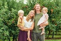 Portrait of happy young family with two little children enjoying good time in apple orchard Royalty Free Stock Photo