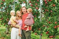 Portrait of happy young family with two little children enjoying good time in apple orchard Royalty Free Stock Photo
