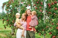 Portrait of happy young family with two little children enjoying good time in apple orchard Royalty Free Stock Photo