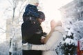 Portrait of a happy young family walking together in a winter city park, sunlight. The son is sitting on Dad& x27;s neck Royalty Free Stock Photo