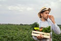 Portrait of a happy young farmer holding fresh vegetables in a basket. On a background of nature The concept of biological, bio Royalty Free Stock Photo