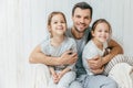 Portrait of happy young father embraces his two daughters, loves Royalty Free Stock Photo