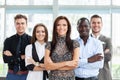 Portrait of a happy young female business leader standing in front of her team. Royalty Free Stock Photo