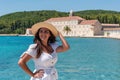 Portrait of happy young female in front of picturesque old stone monastery on Badija island, Croatia Royalty Free Stock Photo