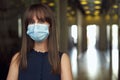Portrait of female office worker in office building hallway, wearing face mask Royalty Free Stock Photo