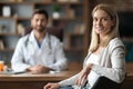 Portrait Of Happy Young Female Patient Sitting At Doctor's Office Royalty Free Stock Photo