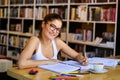 Portrait of happy young female studying in a library. Education study teenager concept Royalty Free Stock Photo