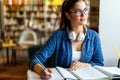 Portrait of happy young female studying in a library. Education study teenager concept Royalty Free Stock Photo