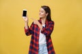 Portrait of a happy young girl dressed in summer pointing finger at blank screen mobile phone isolated over yellow Royalty Free Stock Photo